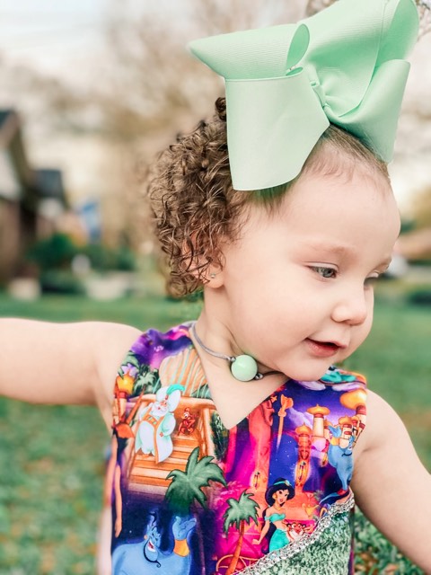 Little girl wearing a green bow